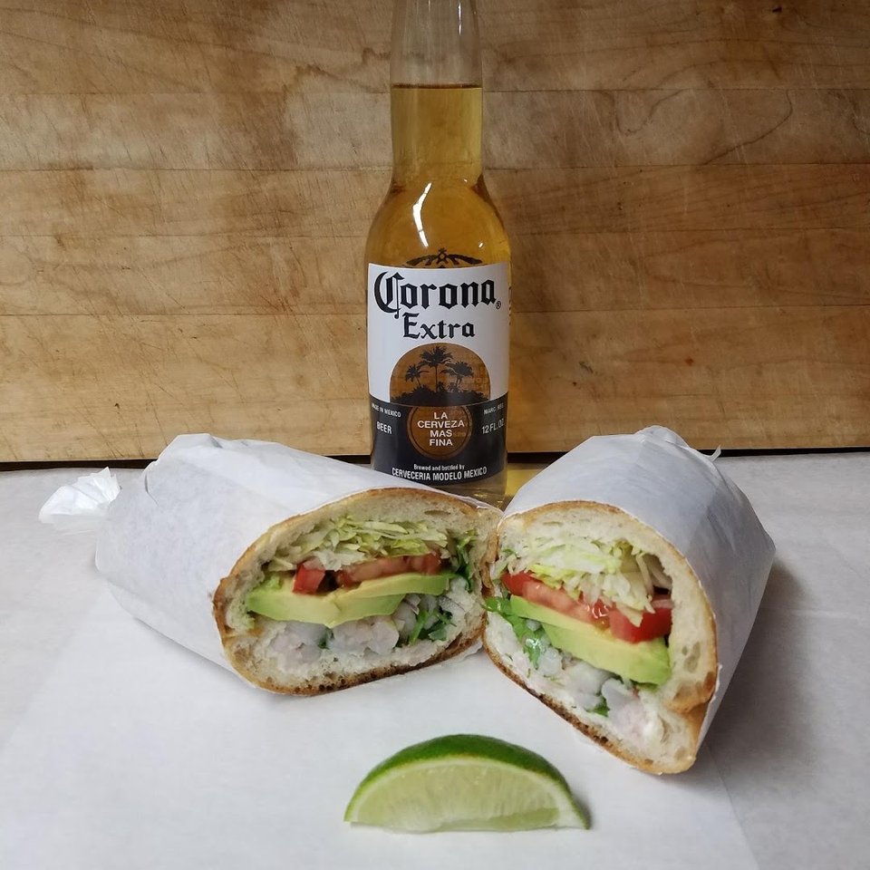 Wrapped sandwiches and cold drinks on a simple counter